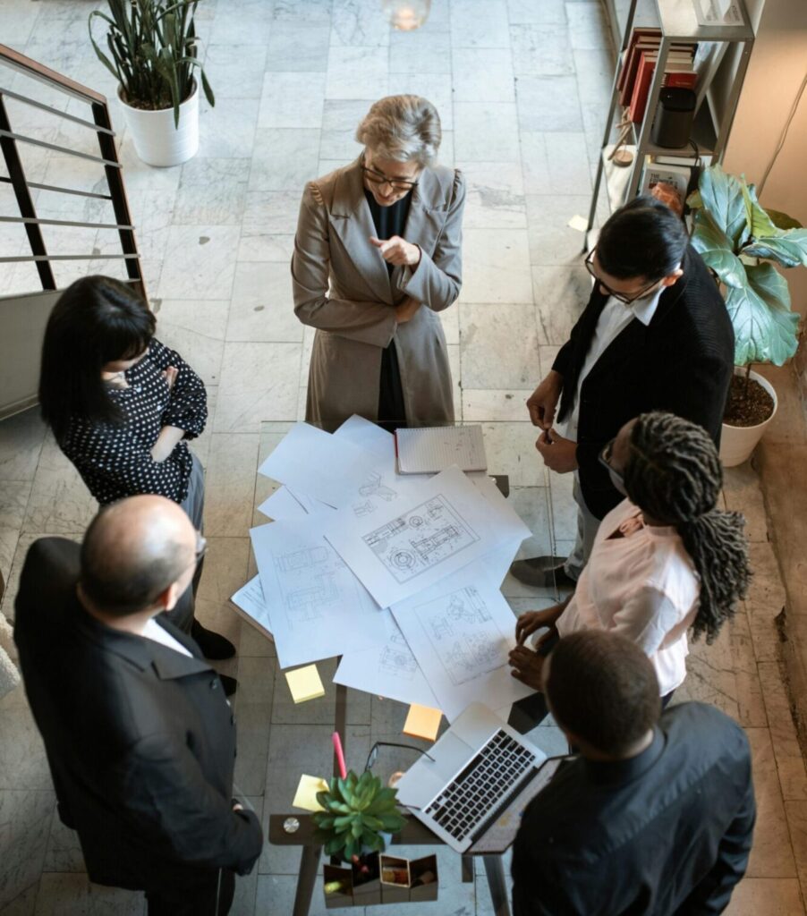 pexels-photo-5922201-5922201 A diverse group of professionals collaborating over documents in a modern office setting.